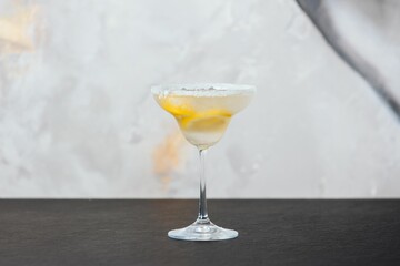 a margarita cocktail on a table with lemon slices around the rim