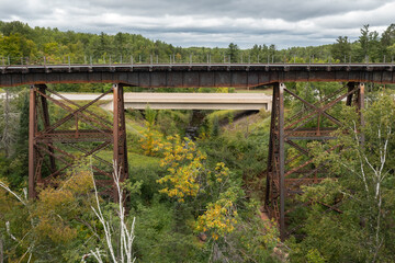 Obraz premium Railroad Trestle Bridge With Highway Bridge Behind