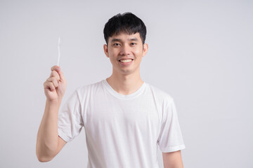 Young handsome man brushing his teeth over isolated background smiling a lot