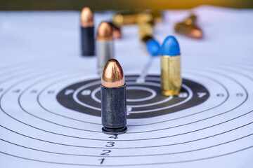 Many bullets on white paper shooting target focus on black bullet The golden bullet head at the...