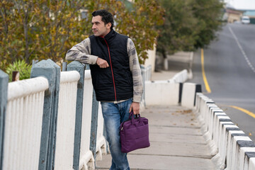 Fototapeta premium Armenian man, different emotional face actions, in the outdoor, the cold temperature, with the jacket, a man with the suitcase enjoying the sightseeing
