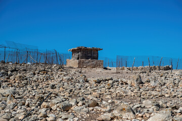 Abandoned building made of old wooden plank at Gavdos island, Crete Greece. Metal fence, blue sky.