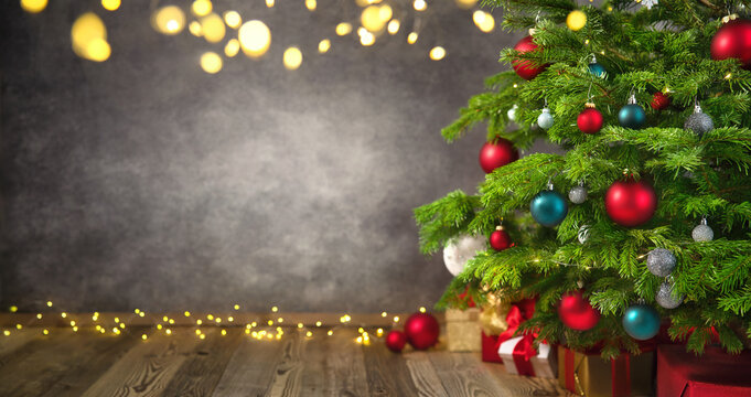 Delightful Christmas tree closeup with textured gray wall as a nice background framed with lights and vignetting