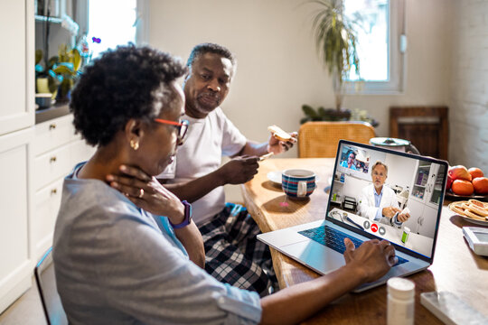 Senior Couple Consults with Doctor via Video Call at Home
