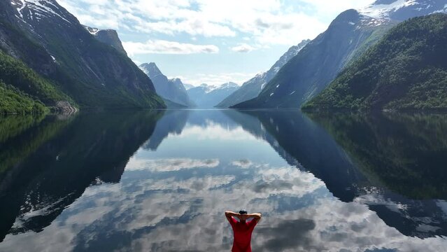 A Man Enjoying Norwegian Scenery From His Camper Van Roof
