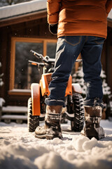 Naklejka premium Winter chores in country house. Man using snowplow to clear path from deep snow in courtyard of residential building after snowfall