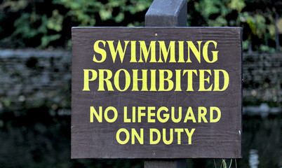 swimming prohibited no lifeguard on duty sign at famous swimming hole (waterfall in ithaca) safety, life guard, drowning threat, water sport, swim, summer (no swimming allowed)