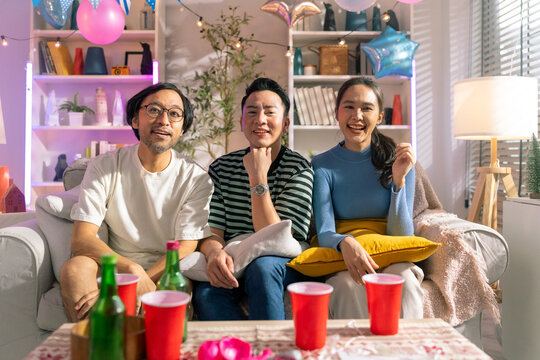 portrait shot of fun and playful laugh cheering joyful together in christmas and new year party on sofa couch at home fun photo group shot friend in home party