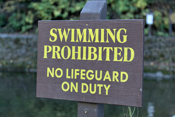 swimming prohibited no lifeguard on duty sign at famous swimming hole (waterfall in ithaca) safety, life guard, drowning threat, water sport, swim, summer (no swimming allowed)