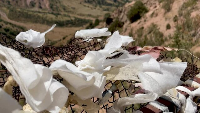 ribbons of desires tied to fancy against backdrop of a mountain and blue sky on Chimgan mountain, Uzbekistan