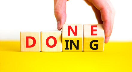 Doing and done symbol. Concept words Doing Done on wooden block. Beautiful yellow table white background. Businessman hand. Business doing and done concept. Copy space. © Dzmitry