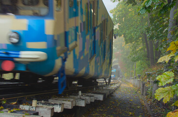 Foggy autumn landscape with the Kyiv Funicular. Two Cabins with passengers goings towards to each other. Blurred motion. Funicular is popular transport among locals and tourists. Tourism concept