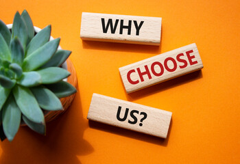 Why choose us symbol. Concept words Why choose us on wooden blocks. Beautiful orange background...