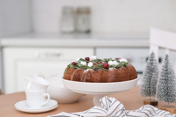 Christmas chocolate bundt cake with fresh berries and rosemary. Winter baking at Christmas or New Year with decorations.Teapot and cups of tea..