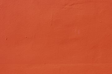 The surface of an old wall with red plaster.