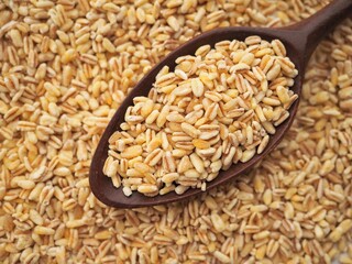 Cereal background with wheat grains and a spoon 