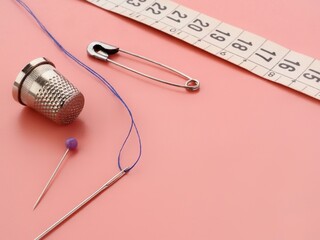 Sewing accessories on a pink background and copy space 