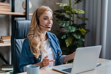 Caucasian mature business woman customer service agent, support team worker talking with customers in call center, assisting clients on phone with laptop. Online webinar - obrazy, fototapety, plakaty