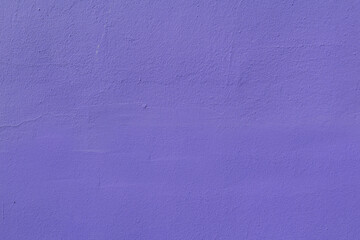 The surface of an old purple wall damaged by time.