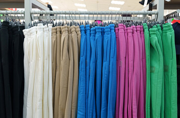 Beautiful women's trousers hanging on hangers, sold in a fashion store.