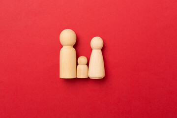 Wooden family figures on color background, top view