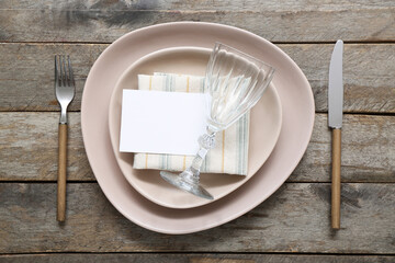 Stylish modern table setting with card on brown wooden background