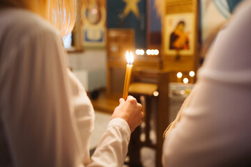 Orthodox church candle background. Hand holding candle during ceremony. Baptism ceremony in East of Europe. - obrazy, fototapety, plakaty