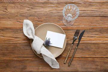 Stylish modern table setting with card on brown wooden background