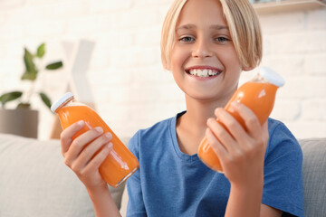 Little boy with bottles of juice at home, closeup