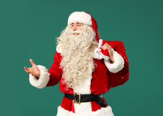 Fototapeta na wymiar Portrait of Santa Claus with bag of gifts on green background