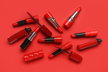 Different stylish new lipsticks on red background