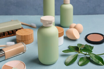 Set of cosmetic products and makeup sponges on color table