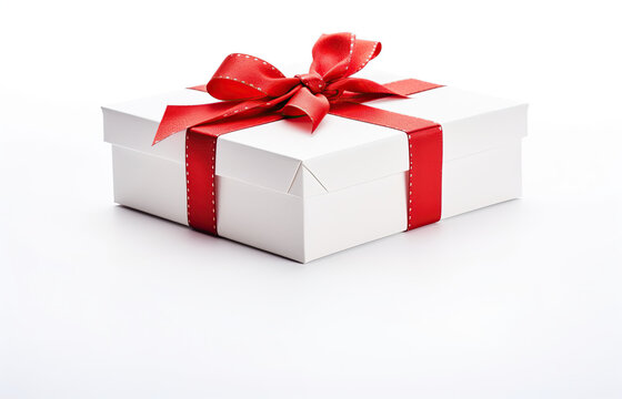 white wide flat gift box with red bow with tiny gold stiches. Over a white background 