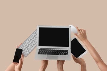 Women with modern gadgets on beige background