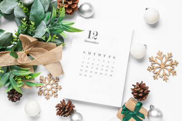 Paper calendar for December 12 with mistletoe wreath, gift box and Christmas decorations on grey background