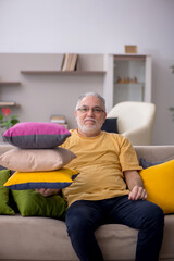 Fototapeta premium Old man with many pillows at home