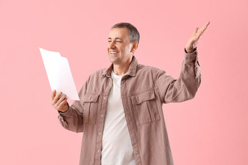 Mature actor with film script on pink background - obrazy, fototapety, plakaty