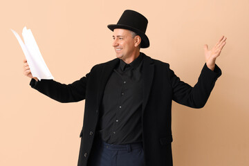 Mature actor reading film script on beige background