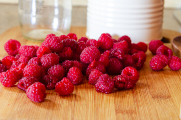 Red raspberries on a wooden board ready for making jam