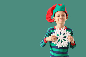Cute little boy in elf costume with snowflake on green background