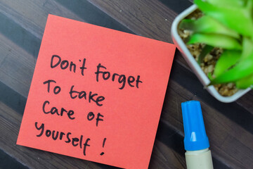 Concept of Don't Forget To Take Care Of Yourself! write on sticky notes isolated on Wooden Table.