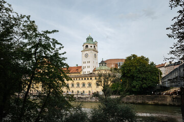 Fototapeta na wymiar Tower of the Müller’sches Volksbad public pool in Munich Germany, Isar river and trees, cloudy day