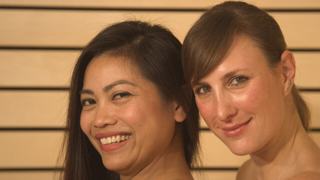PORTRAIT, CLOSE UP: Two beautiful young women at wellness smiling into camera