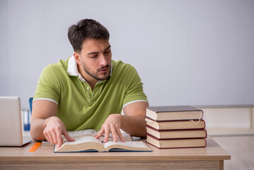 Young male student sitting in front of whiteboard