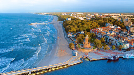This aerial shot focuses on Kołobrzeg's iconic lighthouse and the thriving harbor beneath it. The coastal charm, combined with the maritime atmosphere of this Polish gem, is beautifully showcased.