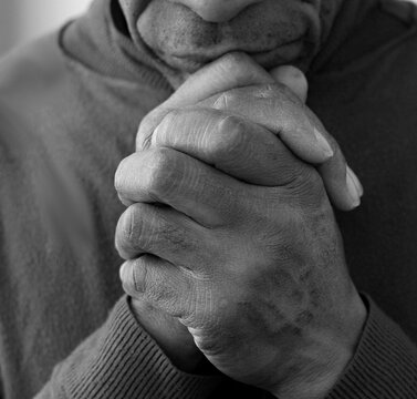 black man praying to God on grey black background with people stock image stock photo
