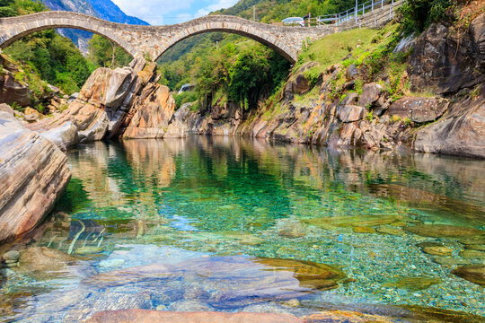Ancient double arch stone Roman bridge (Ponte dei Salti) over the clear water of the Verzasca river in Lavertezzo ,Verzasca Valley, Ticino Canton, Switzerland
