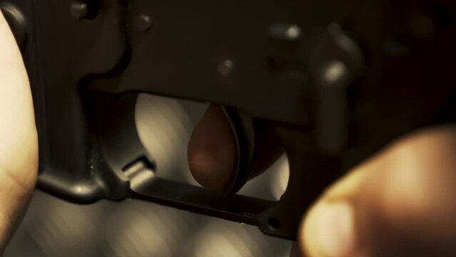 Pulling the trigger on a machine gun close-up of a hand-held firearm