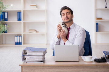 Young male employee holding moneybag