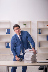Young male employee unhappy with excessive work in the office